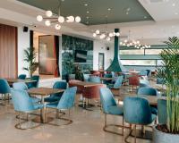 a restaurant with blue chairs and tables in a cafeteria at AKROTHEA suites & lounge in Tripolis