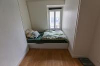 ein kleines Bett in einem kleinen Zimmer mit Fenster in der Unterkunft Comfortable and spacious apartment in Paris 3rd in Paris
