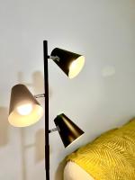 a lamp next to a bed with a yellow blanket at Appartement cosy à Toulouse in Toulouse