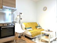 a living room with a yellow couch and a stove at Appartement cosy à Toulouse in Toulouse