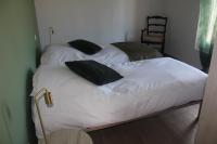 a bed with black pillows on it in a room at Gîte de charme pour 10 personnes in Camélas