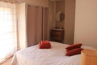 a bedroom with a white bed with red pillows on it at Gîte de charme pour 10 personnes in Camélas