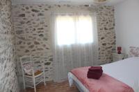 a bedroom with a bed and a window and a chair at Gîte de charme pour 10 personnes in Camélas