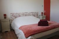 a bedroom with a white bed with a red and white blanket at Gîte de charme pour 10 personnes in Camélas