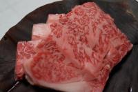 uma pilha de carne vermelha em um prato de madeira em Kazeya em Takayama