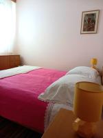 a bedroom with a bed with a pink blanket at Kat&#39;s - Roman Salona in Solin