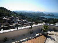a balcony with a view of the ocean and mountains at Chiu Chunt Dint B&amp;B in Jiufen