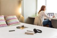 Eine Frau, die an einem Schreibtisch in einem Zimmer sitzt. in der Unterkunft Campanile Paris Est - Pantin in Pantin