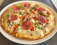 Secret Garden Hotel في ماليم: بيتزا بيبيروني على صحن على طاولة