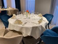 a table with a white table cloth and a red flower on it at Hotel Sonne Sissach in Sissach