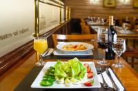 a table with a plate of food and glasses of wine at Rio Aeroporto Hotel Galeão in Rio de Janeiro