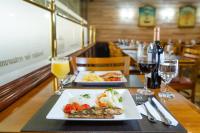 a table with two plates of food and glasses of wine at Rio Aeroporto Hotel Galeão in Rio de Janeiro