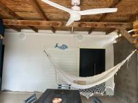 a ceiling fan and a hammock in a room at Yeux D&#39;azur in Le Souffleur