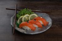 Un plato de sushi con pescado y verduras y palillos. en Torino Hotel Amman, en Amán