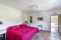 a bedroom with a large bed with a pink blanket at Villa de 6 chambres avec piscine privee jardin clos et wifi a Saignon in Saignon