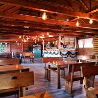 an empty restaurant with wooden tables and benches at Zmaj Ognjeni Etno Concept in Kupinovo