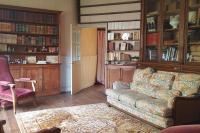 a living room with a couch and some book shelves at La Volière in Champigny-sur-Veude