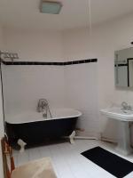 a bathroom with a black and white tub and a sink at La Volière in Champigny-sur-Veude