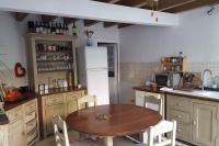 a kitchen with a wooden table and a refrigerator at La Volière in Champigny-sur-Veude