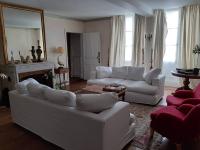 a living room with two white couches and a mirror at La Volière in Champigny-sur-Veude
