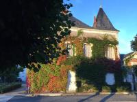 a building covered in ivy on the side of a street at La Volière in Champigny-sur-Veude