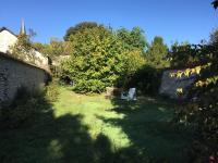 a yard with a chair sitting in the grass at La Volière in Champigny-sur-Veude