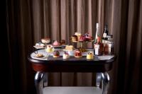 Una mesa llena de cupcakes y botellas de vino. en Mayfair Hotel, en Adelaida