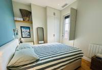 a bedroom with a large bed with a striped blanket at Panorama des Chartrons in Bordeaux