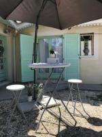 a table and two stools in front of a house at Village Drôles d&#39;Oiseaux in Le Teich