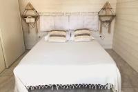 a bedroom with a large white bed with two pillows at Village Drôles d&#39;Oiseaux in Le Teich