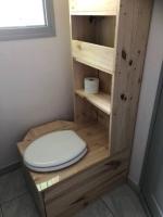 a bathroom with a toilet in a wooden cabinet at Village Drôles d&#39;Oiseaux in Le Teich