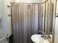 a bathroom with a shower curtain and a sink at Village Drôles d&#39;Oiseaux in Le Teich