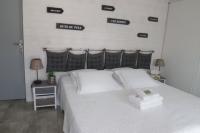 a bedroom with a white bed with signs on the wall at Village Drôles d&#39;Oiseaux in Le Teich