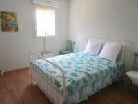 a bedroom with a bed with a blue and white comforter at Appartement Capbreton, 3 pièces, 4 personnes - FR-1-239-453 in Capbreton