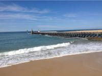a beach with a pier in the ocean with waves at Appartement Capbreton, 3 pièces, 4 personnes - FR-1-239-453 in Capbreton