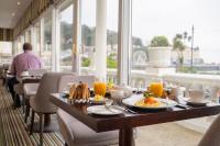 a table with food and orange juice on it in a restaurant at St George's Hotel - Llandudno in Llandudno