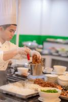 a chef is preparing food in a kitchen at Cat Ba Wonder Hotel in Cat Ba