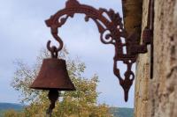 a bell hanging on the side of a building at Maison périgourdine avec vue et piscine chauffée in Peyzac-le-Moustier