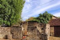 an old stone building with a tree next to it at Maison périgourdine avec vue et piscine chauffée in Peyzac-le-Moustier