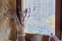 a vase filled with dried grass sitting next to a window at Maison périgourdine avec vue et piscine chauffée in Peyzac-le-Moustier