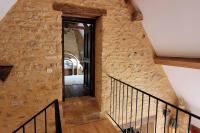 a staircase in a building with a stone wall at Maison périgourdine avec vue et piscine chauffée in Peyzac-le-Moustier