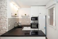 a kitchen with white appliances and a black counter top at Appartement cosy à 10 min de Disneyland Paris ! in Montévrain