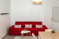 a red couch in a living room with a table at Appartement cosy à 10 min de Disneyland Paris ! in Montévrain