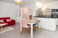a kitchen and a living room with a table and chairs at Appartement cosy à 10 min de Disneyland Paris ! in Montévrain