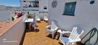 a balcony with chairs and tables on a building at Holiday home La Atalaya de Vejer in Vejer de la Frontera