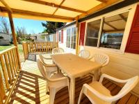 a wooden deck with a table and chairs on a house at Bungalow L&#39;Estagnol - 3 chambres in Sigean
