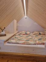 ein Bett in einem Zimmer mit Holzdecke in der Unterkunft Apartmány U 3 Zbujů in Malenovice