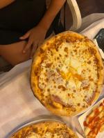 pizza leżąca na stole z dwiema pizzami w obiekcie Hotel Arsenal w mieście Ksamil