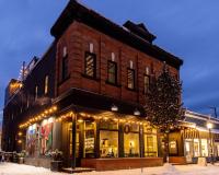 un edificio de ladrillo con un árbol de Navidad delante de él en Eleven Revelstoke Lodge, en Revelstoke