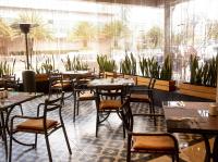 a restaurant with tables and chairs and a large window at La Quinta by Wyndham Quito in Quito